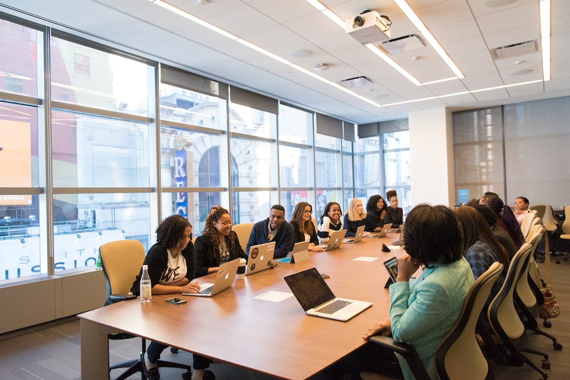 Photo of people in a large conference room having a meeting.