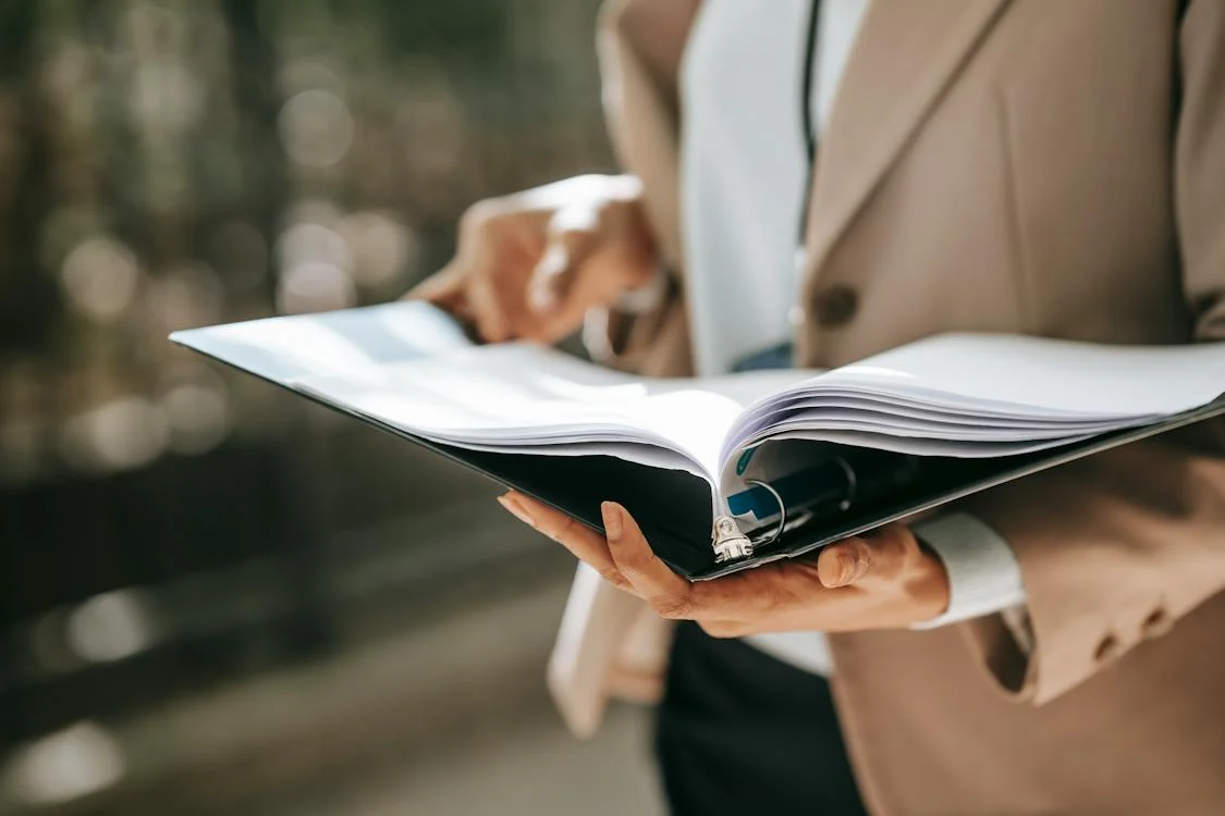 Closeup photo of someone reading documents in a binder.