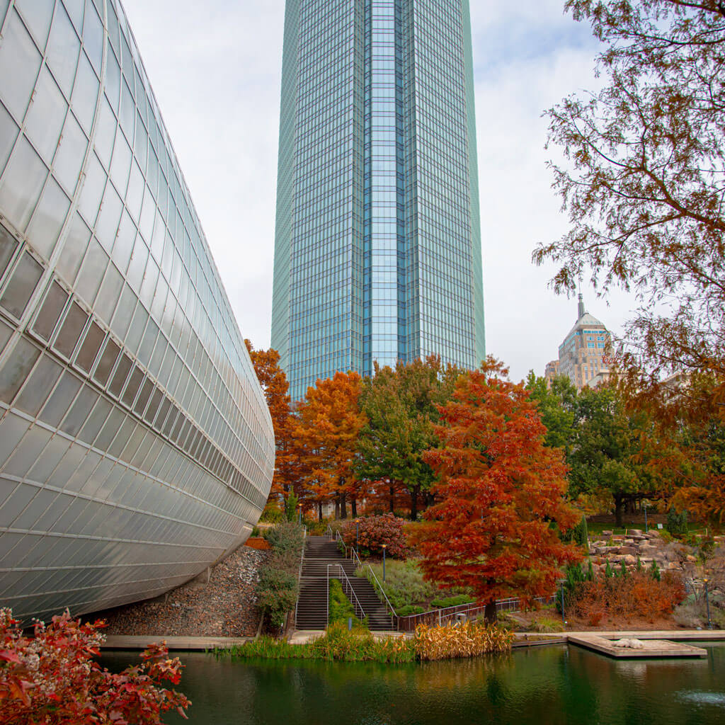 A scenic view of glass high-rise building by a river and green space in Oklahoma City, Oklahoma.