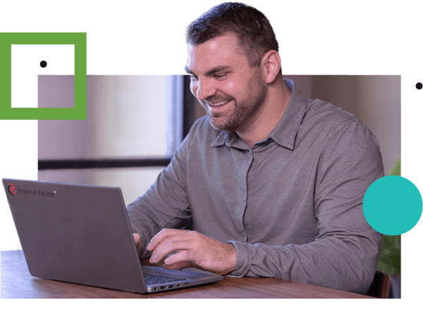 A smiling man working on a laptop computer reviewing PEO services from Employer Flexible.