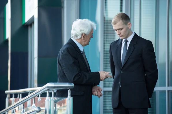 Photo of senior businessman talking with his employee.